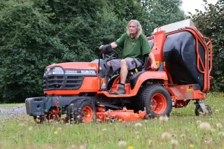 Traktorová sekačka Kubota BX2200 při jízdě po trávníku.