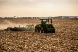 Autonomní traktor John Deere 9RX při práci na poli.