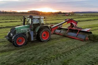 Traktor s pásovým shrnovačem Anderson MergePro 915 na louce.