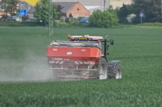 Traktor s rozmetadlem hnojiv RAUCH AXIS na poli