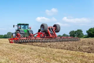 Traktor s diskovým podmítačem Kverneland na poli