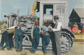 Historická fotografie traktoru a pracovníků společnosti Caterpillar