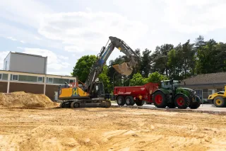 Nakladač u sklápěče Krampe před výrobní halou