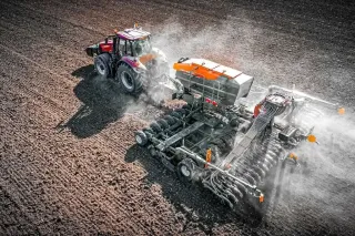 Traktor se secím strojem Amazone Cirrus na poli z nadhledu