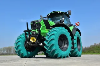 Zelený traktor s tyrkysovými pneumatikami při testování