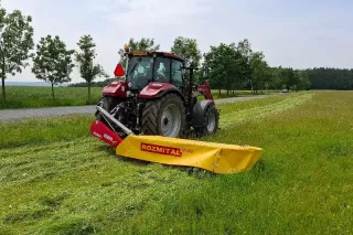 Traktor s čelní sekačkou Rozmital při sečení louky