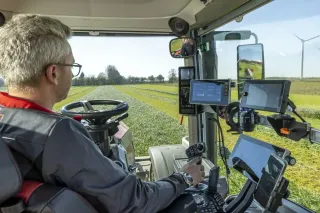 Řidič v kabině traktoru Massey Ferguson při práci na poli