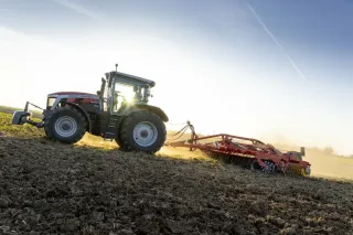 Traktor Massey Ferguson při práci na poli v protisvětle