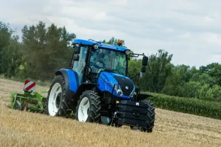 Modrý traktor New Holland na poli
