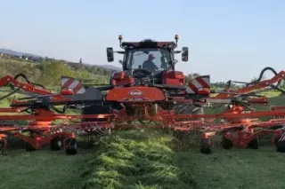 Červený zemědělský stroj KUHN při práci na poli