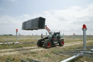 Teleskopický manipulátor Bobcat přepravuje konstrukci na stavbě