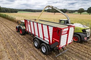 Traktor s přívěsem při sklizni na poli