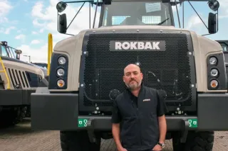 Muž před kloubovým sklápěčem Rokbak