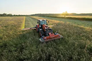 Traktor Kubota se žacími stroji při sečení louky