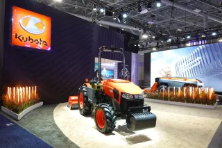 Oranžový traktor Kubota na výstavním stánku