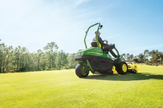 Obsluha jede na sekačce John Deere po trávníku