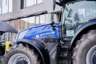 Modrý traktor New Holland před budovou