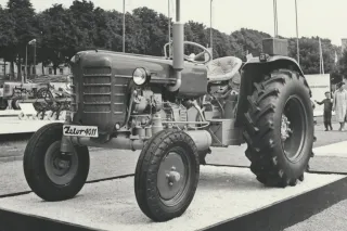 Historický černobílý snímek traktoru Zetor 4011 na výstavním podstavci.