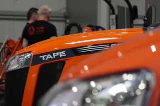 Detail oranžové kapoty traktoru TAFE se značkou a předním světlometem.