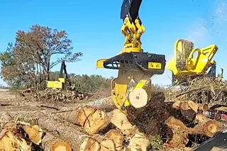 Drapák Tigercat vybavený integrovanou pilou