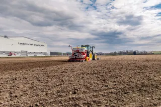 Traktor se secím strojem PÖTTINGER AEROSEM M na poli