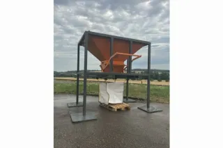 Oranžová plnicí násypka na kovovém rámu