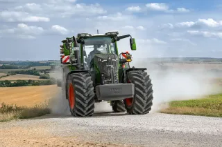 Zelený traktor Fendt při jízdě na poli
