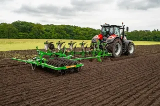 Traktor s pluhem AMAZONE při orbě pole