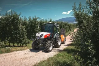 Traktor Steyr mezi řadami ovocných stromů