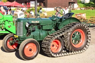 Historický zelený traktor Zetor s přídavnými pásy na přehlídce v Kropáčově Vrutici.