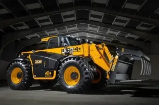 Žlutočerný teleskopický manipulátor JCB Loadall v hale