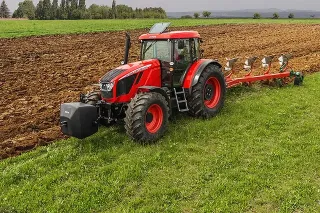 Červený traktor Zetor Crystal při práci na poli