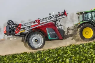 Tažený postřikovač Kverneland za traktorem John Deere na poli