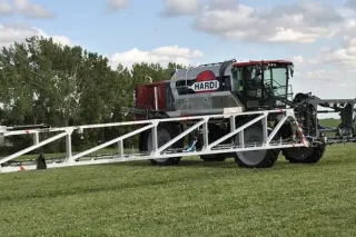 Samojízdný postřikovač Hardi Rubicon s rozloženými rameny na poli