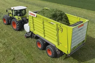 Traktor Claas táhne zelený senážní vůz Cargos