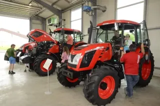 Návštěvníci u červených traktorů Zetor ve výstavní hale