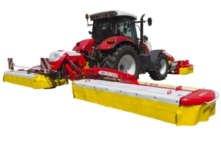 Červený traktor se žlutočervenou žací kombinací na bílém pozadí