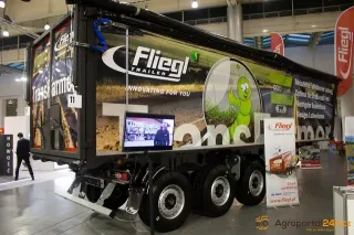 Černý návěs Fliegl TransFarmer vystavený v hale veletrhu