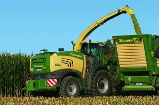 Řezačka Krone Big X plní vůz při sklizni kukuřice