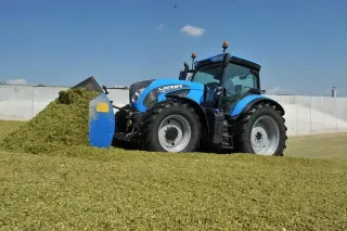 Modrý traktor Landini při práci na silážní jámě
