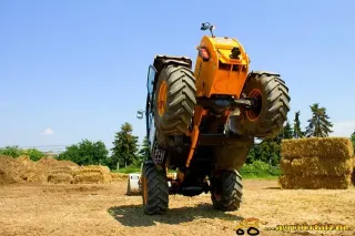 Žlutý manipulátor JCB zvednutý nad zemí