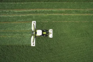 Letecký pohled na traktor Claas s žacími stroji při sečení louky