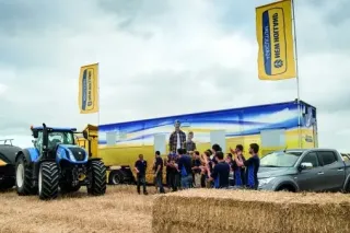 Účastníci polní ukázky u traktorů New Holland