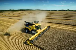 Žlutá sklízecí mlátička New Holland při sklizni obilí