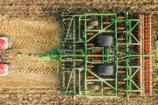 Kombinovaný kypřič Amazone Ceus za červeným traktorem na poli