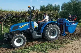 Modrý sadový traktor New Holland ve vinici