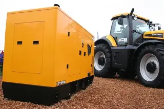 Žlutý generátor JCB vedle traktoru Fastrac