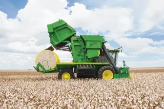 Zelený sklízeč bavlny John Deere na bavlníkovém poli