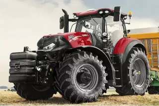 Červený traktor Case IH Optum 250 s předním závažím na poli.
