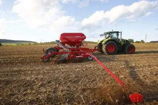 Červený secí stroj Horsch Pronto za traktorem Claas na poli